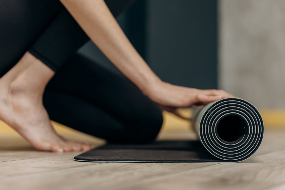 Woman Rolling A Yoga Mat